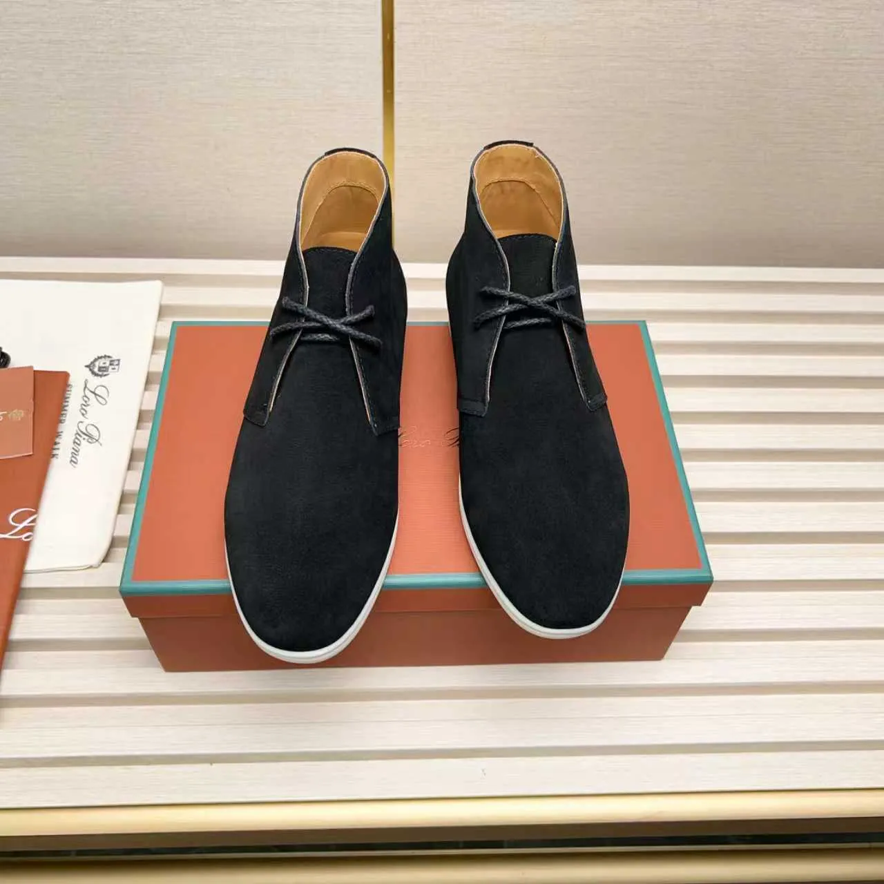 Men's Shoes 💰420 Loro Piana reimagines the desert boot—a modern, comfortable interpretation of a classic 1940s style. Crafted from suede calfskin, it exudes elegance. The tight texture of suede calfskin is not only durable but also looks casual and sophisticated. Add a timeless piece to your shoe collection, harmoniously blending comfort, style and Loro Piana's heritage of craftsmanship. Acetate satin detail on the inside White sole with LP lettering for added traction Space for a personalized signature on the heel Tonal suede trim Upper: 100% cow split suede Sole: 100% Rubber lining: Cow leather